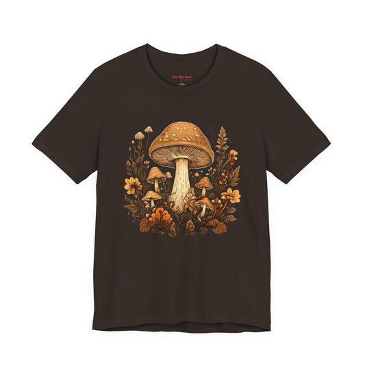 Brown graphic t-shirt featuring vintage style mushrooms surrounded by earthy botanical flowers and woodland plants