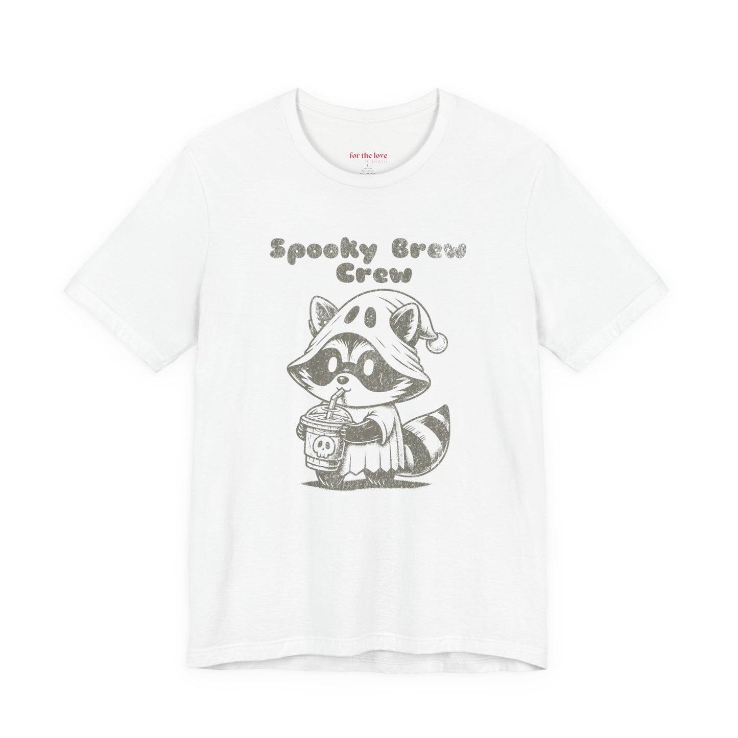 white graphic t-shirt featuring a cute raccoon dressed as a ghost drinking coffee with the words “Spooky Brew Crew”