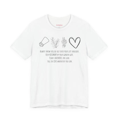 white graphic t-shirt featuring rosemary, lavender, salt, and heart illustrations with a practical magic inspired quote