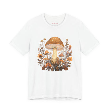 white graphic t-shirt featuring vintage style mushrooms surrounded by earthy botanical flowers and woodland plants